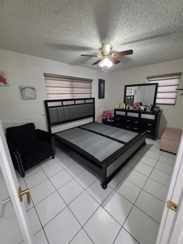 a living room with furniture and a refrigerator
