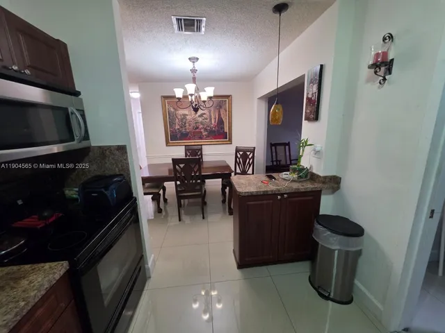 a kitchen with stainless steel appliances granite countertop a refrigerator stove and microwave