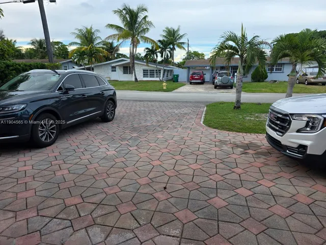 a view of a car parked in front of a house with a yard