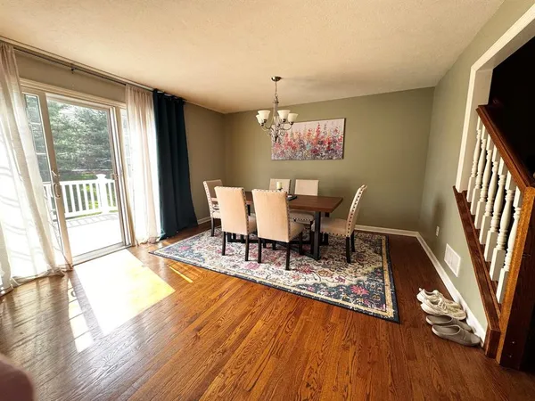 a dining room with wooden floor and a rug