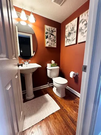 a bathroom with a toilet sink and mirror