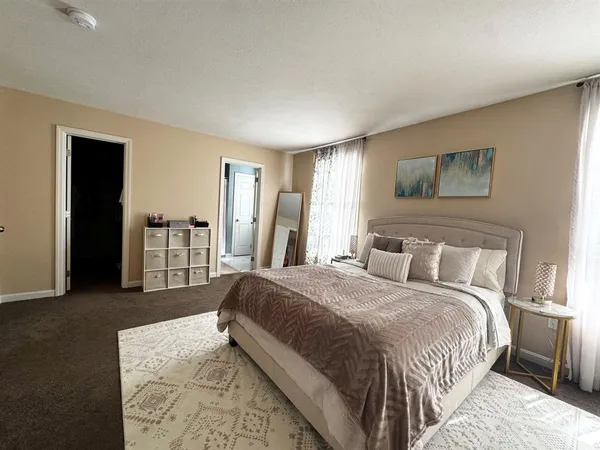 a spacious bedroom with a bed and a dresser