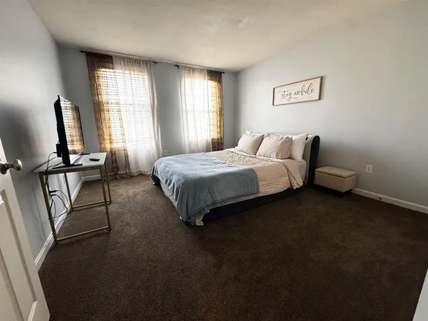 a bedroom with a bed tv and window