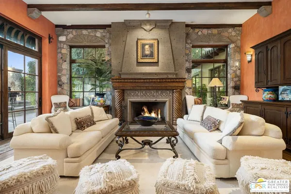 a living room with furniture a large window and a fireplace