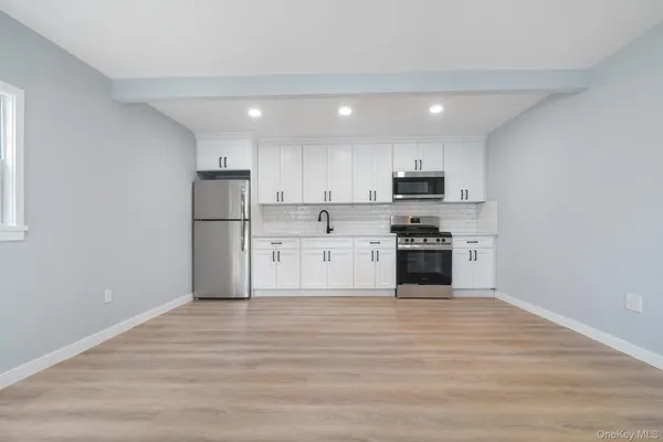 a view of kitchen with granite countertop stainless steel appliances