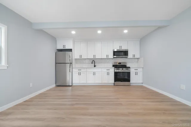 a view of kitchen with granite countertop stainless steel appliances