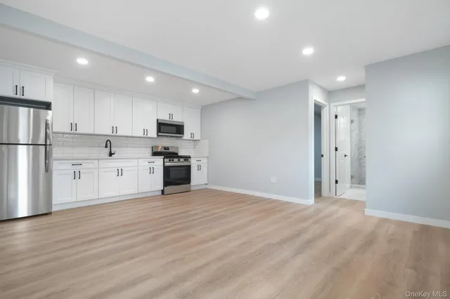 a view of kitchen with granite countertop stainless steel appliances refrigerator sink and cabinets