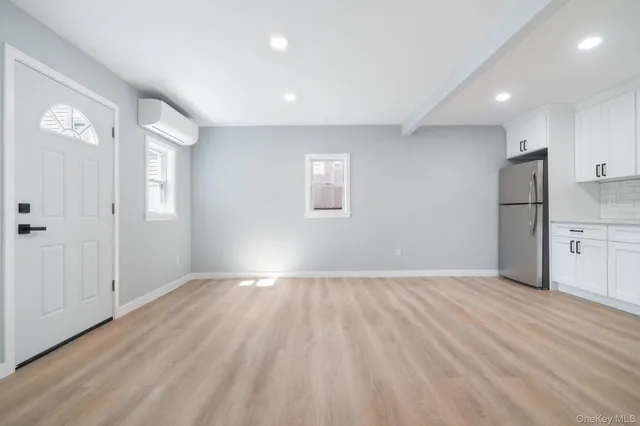 a view of empty room with wooden floor and window