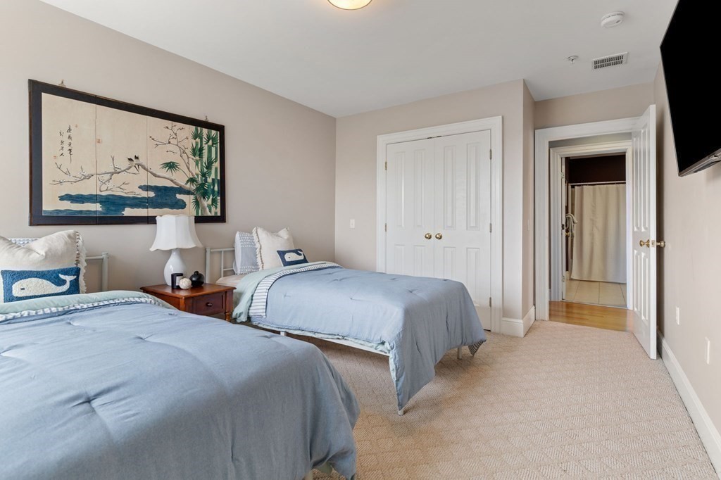 39 Intrepid Circle, Unit 302 Marblehead, MA 01945 - Photo 13 of 32 a bedroom with two beds and a painting on the wall