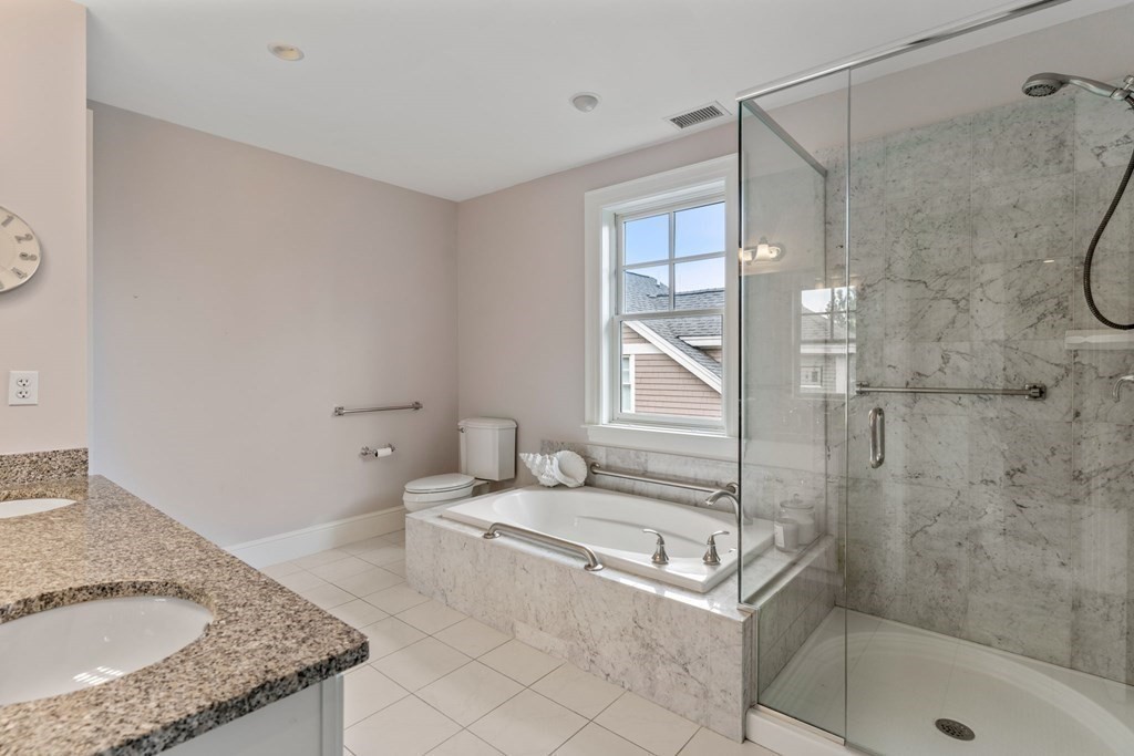 39 Intrepid Circle, Unit 302 Marblehead, MA 01945 - Photo 18 of 32 a bathroom with a granite countertop sink a mirror and a shower
