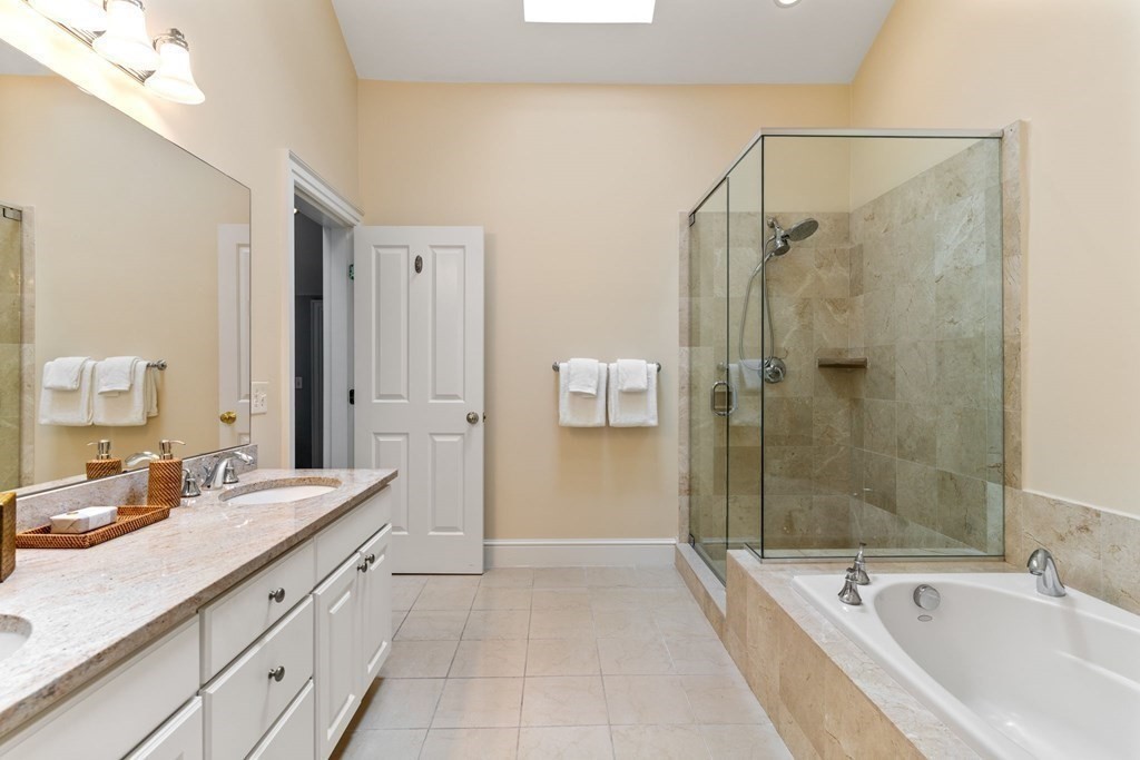39 Intrepid Circle, Unit 302 Marblehead, MA 01945 - Photo 26 of 32 a spacious bathroom with a granite countertop tub sink shower and mirror