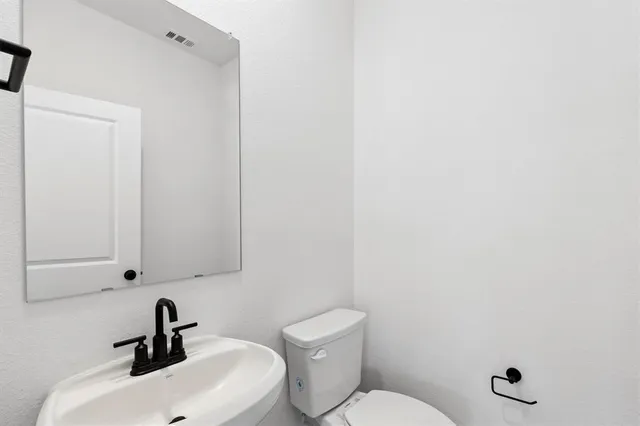 a bathroom with a sink a toilet and a mirror