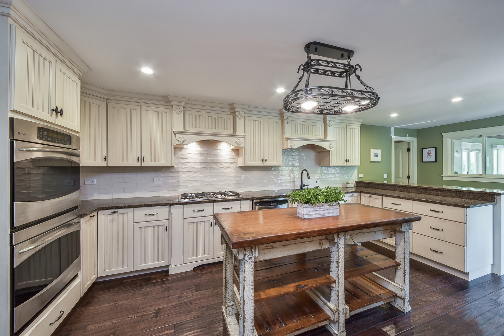 27W355 Mack Road Wheaton, IL 60189 - Photo 7 of 22 a kitchen with stainless steel appliances granite countertop a table chairs stove and white cabinets