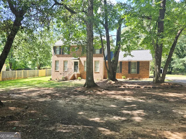 a view of a house with backyard and a tree