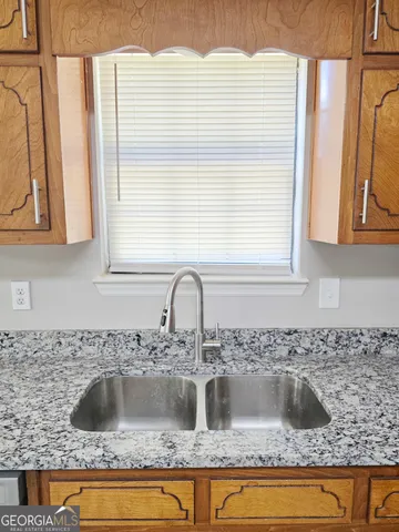 a kitchen with granite countertop a sink and a window