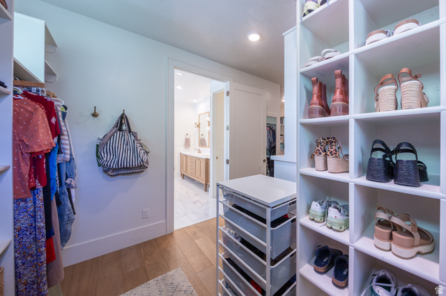 630 East Center Street Alpine, UT 84004 - Photo 46 of 115 Walk-in closet featuring wood-finish flooring, built-in shelving, and a built-in dresser with a white countertop