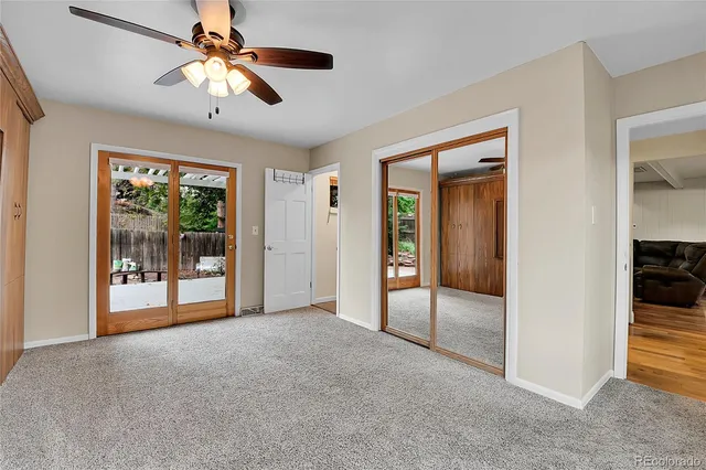 a view of empty room with window and ceiling fan