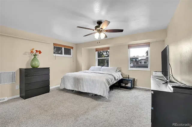 a spacious bedroom with a bed and a chandelier