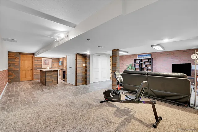 a living room with furniture gym equipment and a window