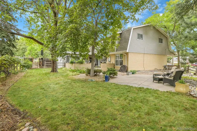 a view of a house with backyard and sitting area