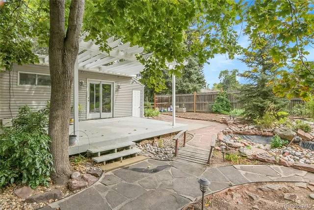 a view of backyard with a table and chairs and potted plants