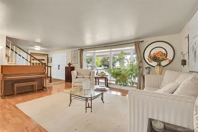 a living room with furniture a clock and a large window