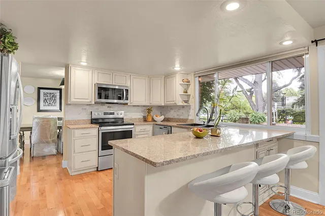 a kitchen with a stove a sink a microwave a dining table and chairs