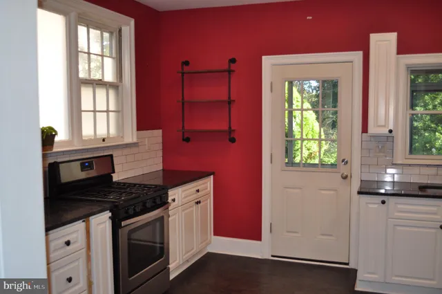 a kitchen with granite countertop a sink stove and cabinets
