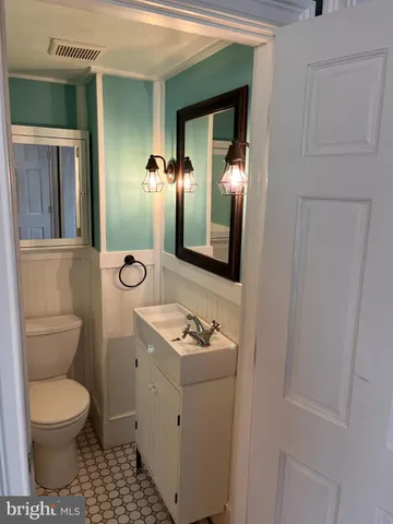 a bathroom with a toilet a sink and mirror