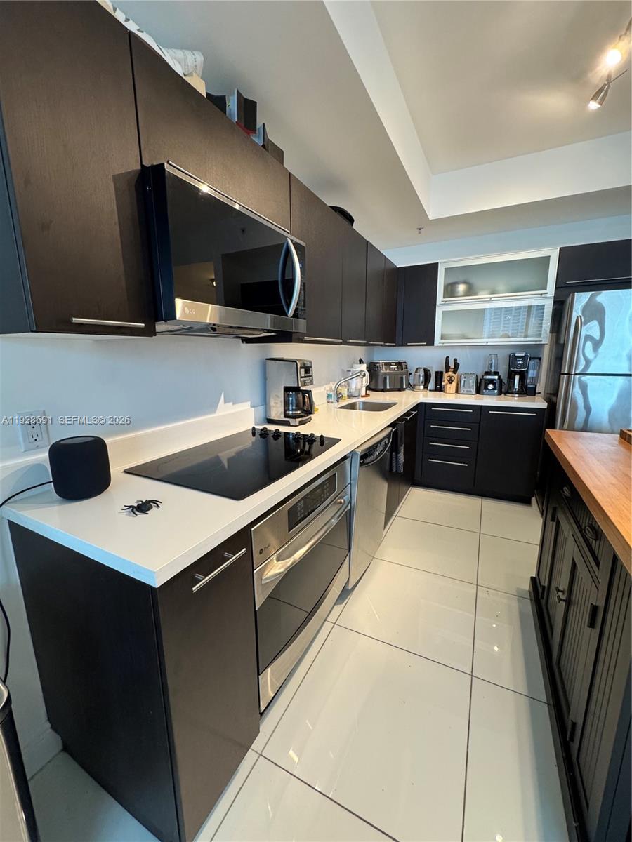 90 Southwest 3rd Street, Unit 3112 Miami, FL 33130 - Photo 10 of 42 a kitchen with stainless steel appliances a sink a stove top oven a counter space and cabinets