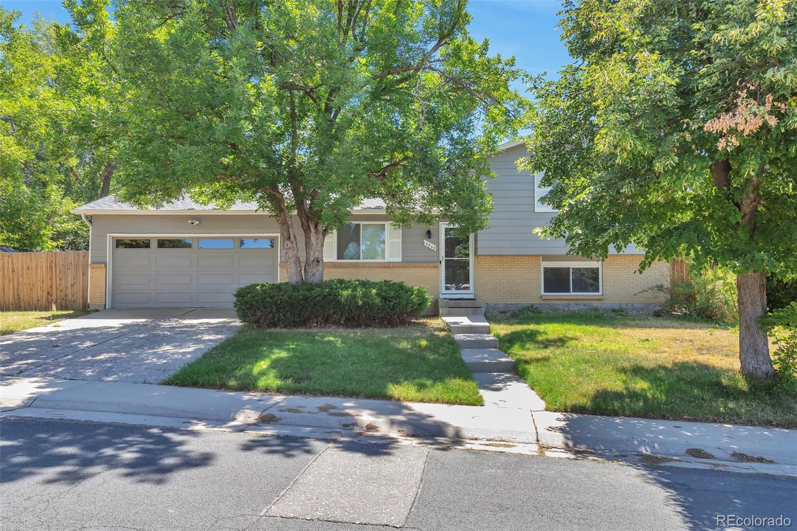 14808 East Tufts Avenue Aurora, CO 80015 - Photo 1 of 25 a front view of a house with a yard and a garage