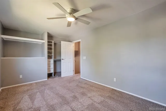 an empty room with closet and fan