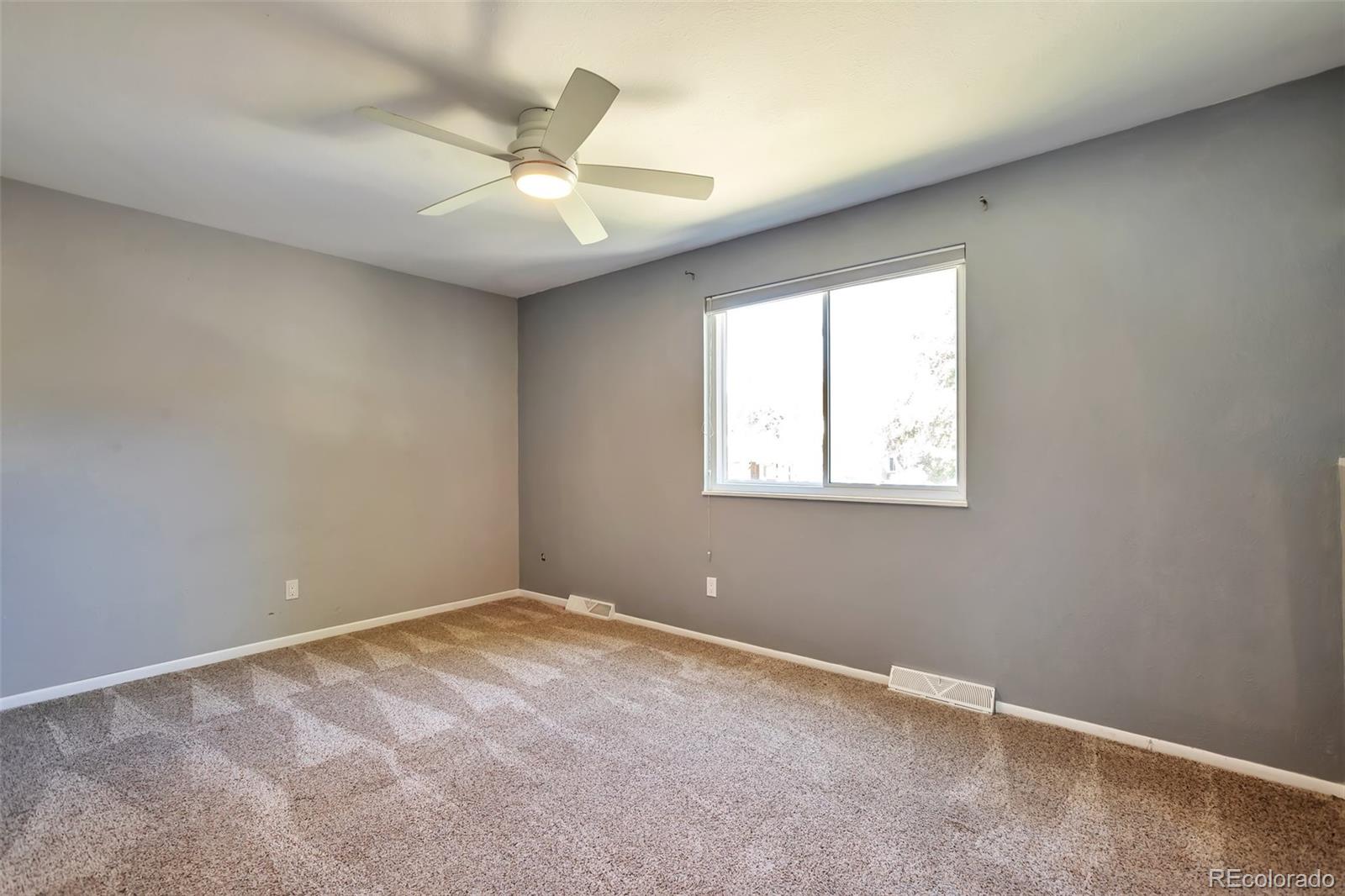 14808 East Tufts Avenue Aurora, CO 80015 - Photo 12 of 25 an empty room with a window and a fan