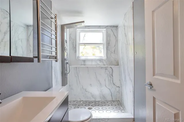 a bathroom with a granite countertop bathtub shower and toilet