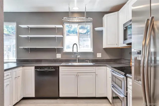 a kitchen with granite countertop white cabinets and a stainless steel appliances