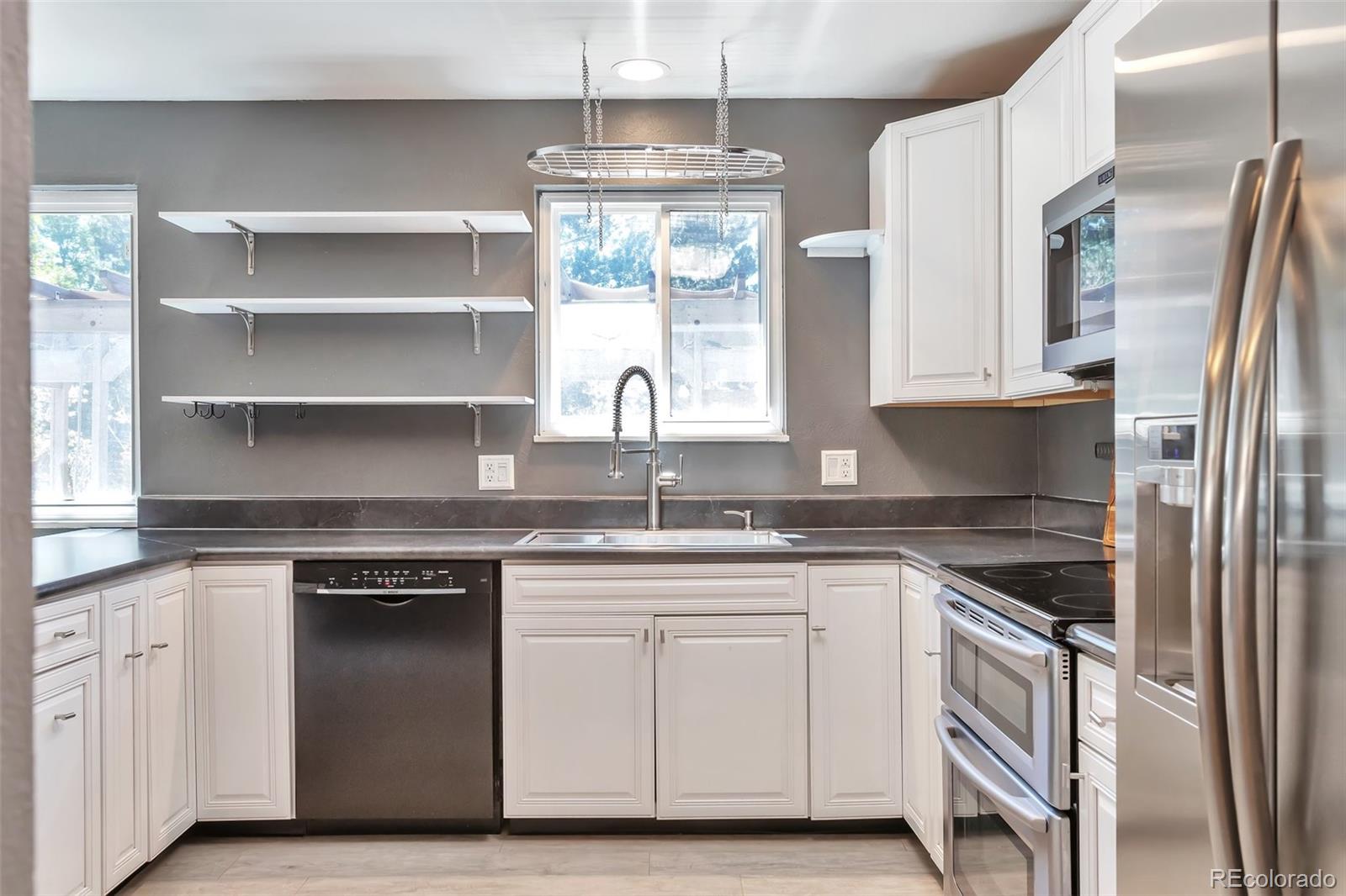 14808 East Tufts Avenue Aurora, CO 80015 - Photo 6 of 25 a kitchen with granite countertop white cabinets and a stainless steel appliances