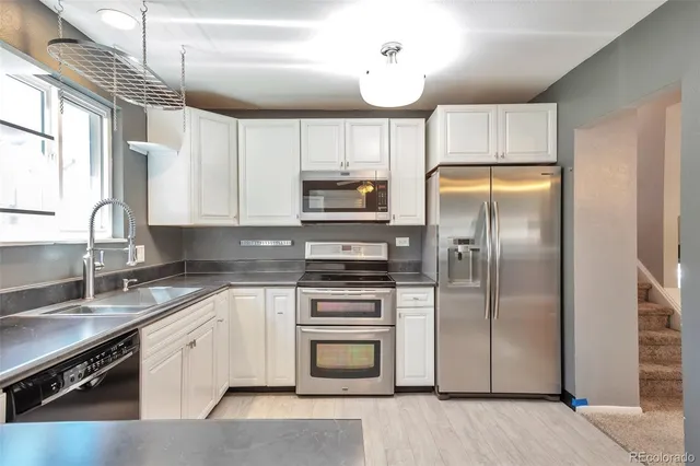a kitchen with a refrigerator sink and cabinets