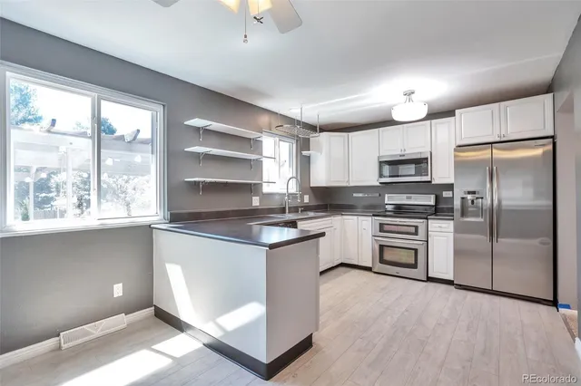 a kitchen with kitchen island white cabinets and refrigerator