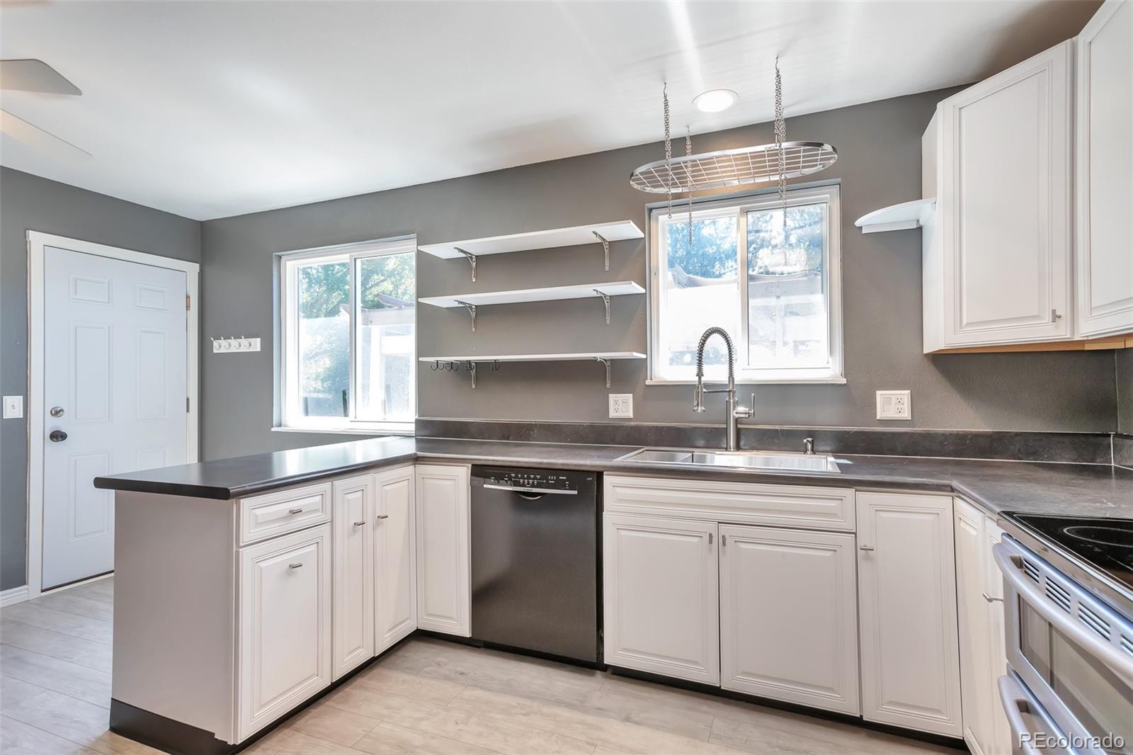14808 East Tufts Avenue Aurora, CO 80015 - Photo 9 of 25 a kitchen with white cabinets appliances a sink and a window