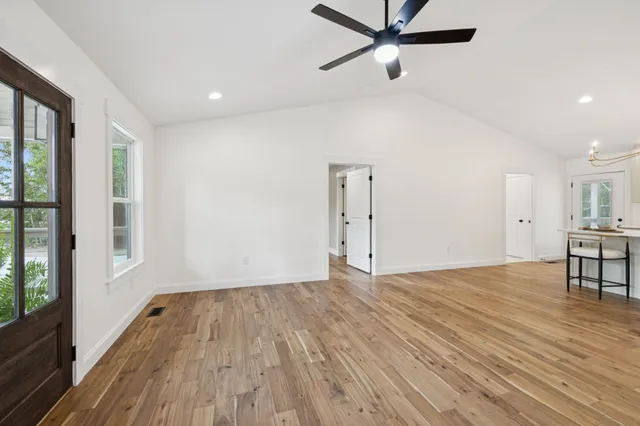 a view of a big room with wooden floor and a ceiling fan