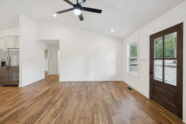 a view of a big room with wooden floor and windows