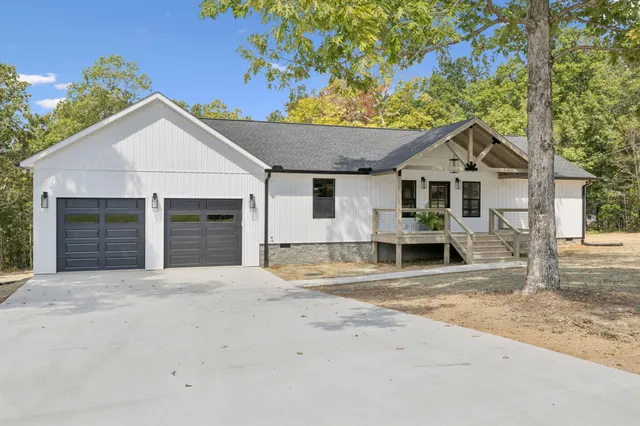 a view of a house with a patio and a yard