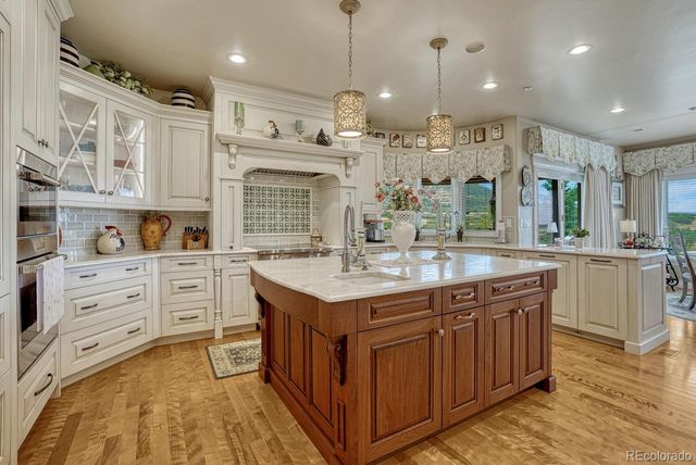 a kitchen with kitchen island granite countertop a sink a counter top space stainless steel appliances and cabinets