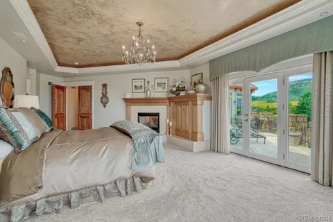 a spacious bedroom with a large bed and a chandelier