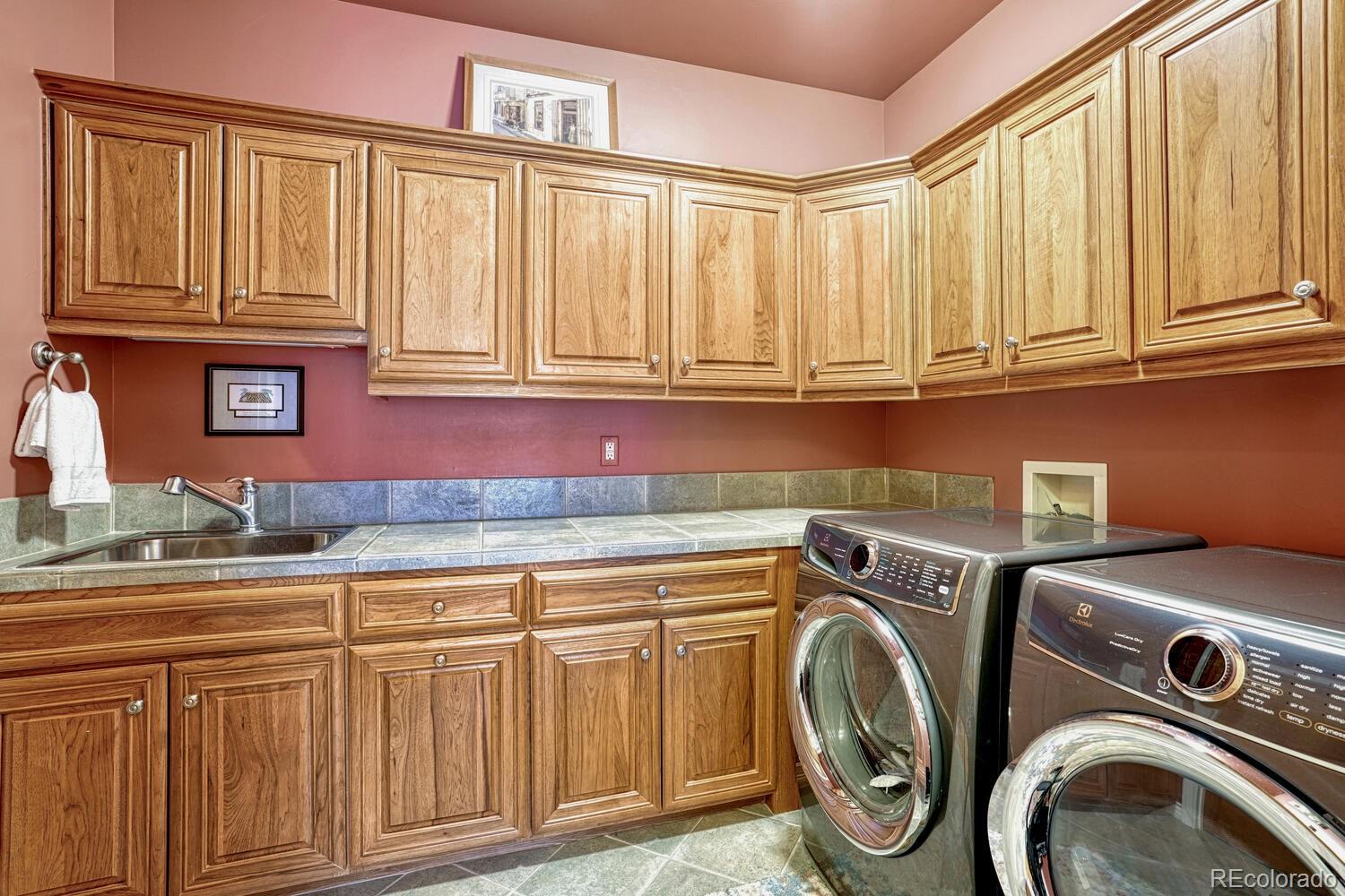 3851 Castle Butte Drive Castle Rock, CO 80109 - Photo 22 of 50 a utility room with granite countertop washer and dryer
