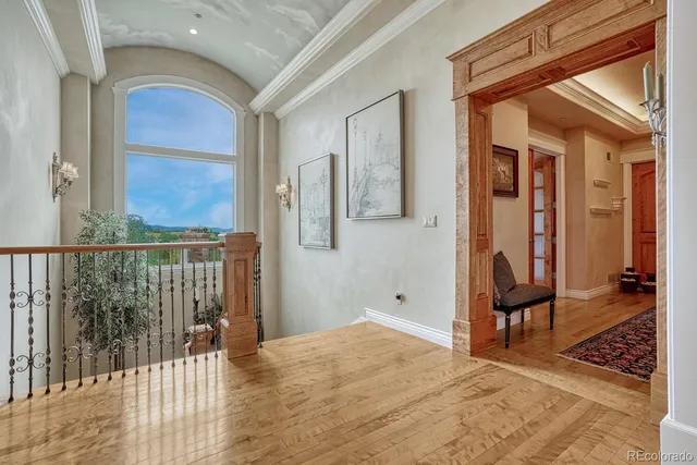 a view of a hallway with wooden floor and windows