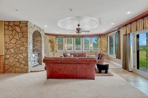 a living room with fireplace furniture and a large window