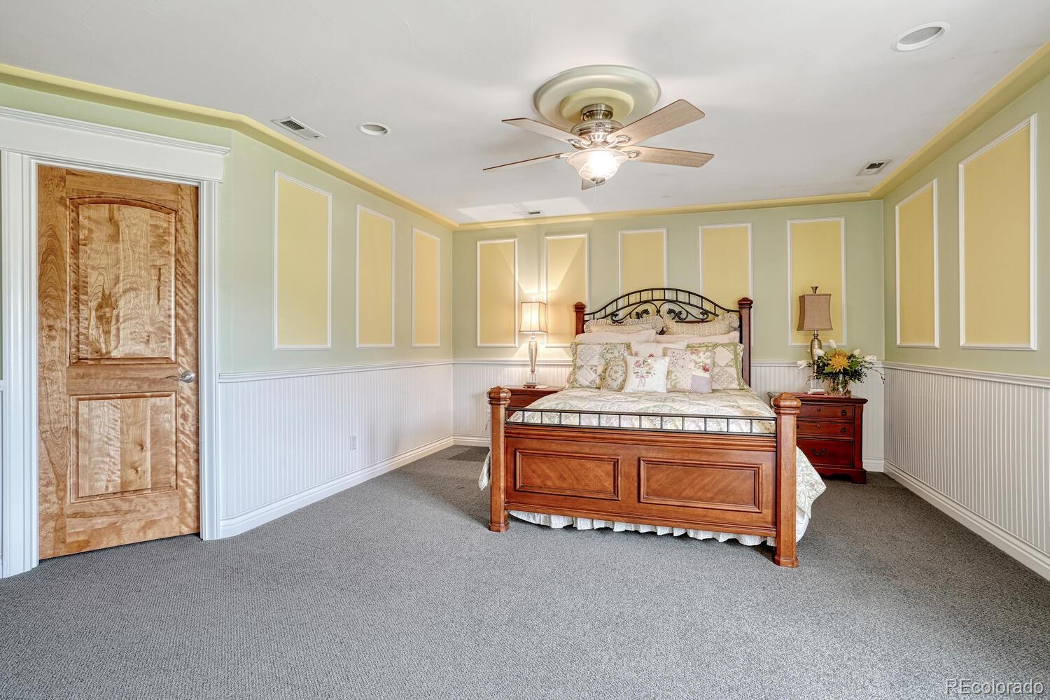 3851 Castle Butte Drive Castle Rock, CO 80109 - Photo 39 of 50 a spacious bedroom with a bed and chandelier