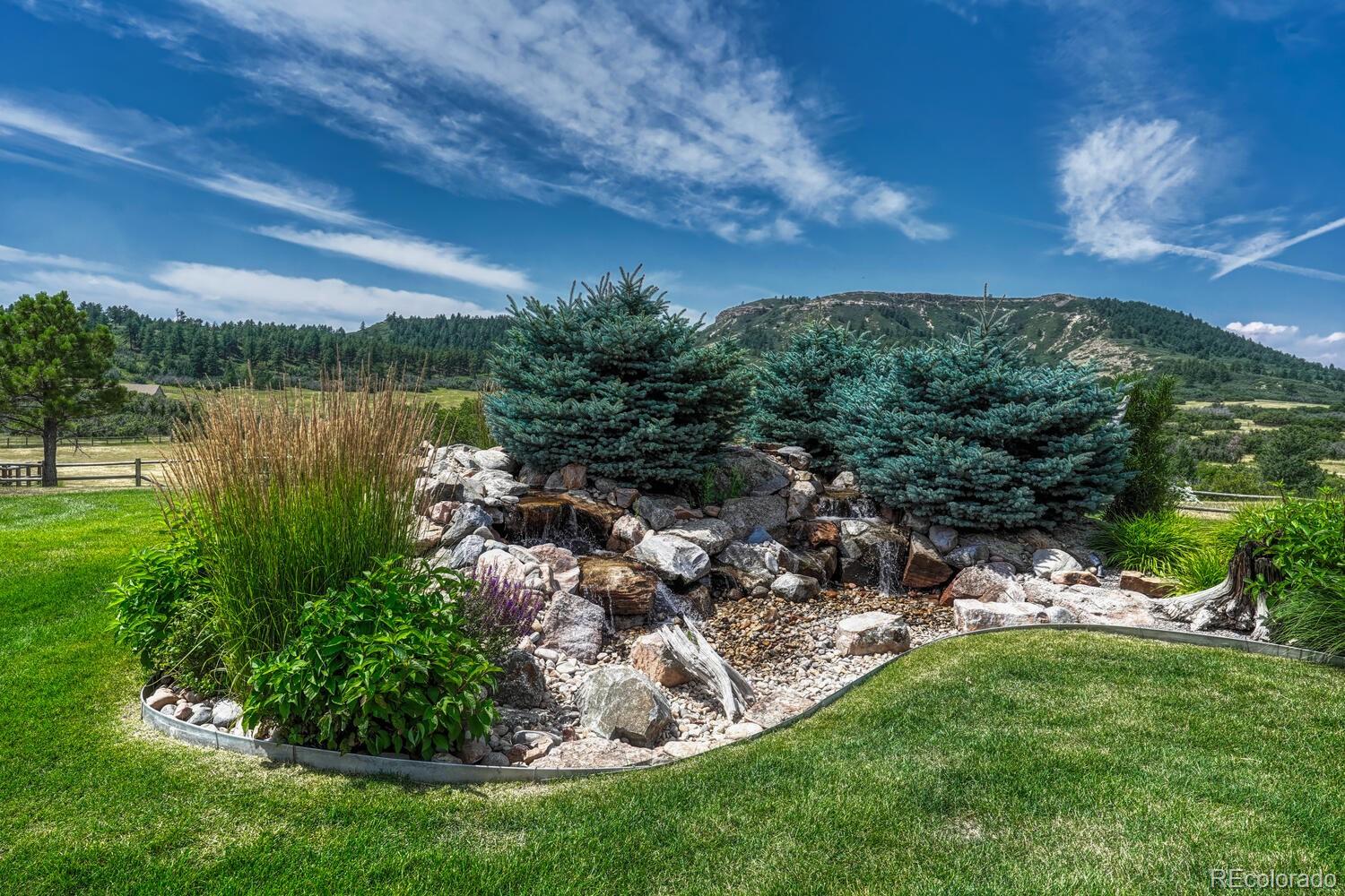 3851 Castle Butte Drive Castle Rock, CO 80109 - Photo 42 of 50 a view of a garden with a lake