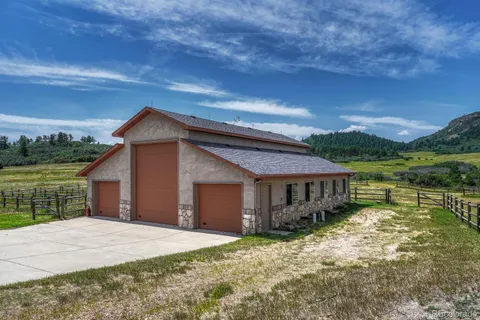 a view of a house with a yard balcony and wooden fence